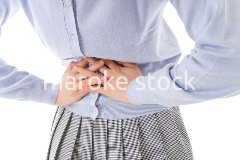 腹痛に苦しむ若い女性