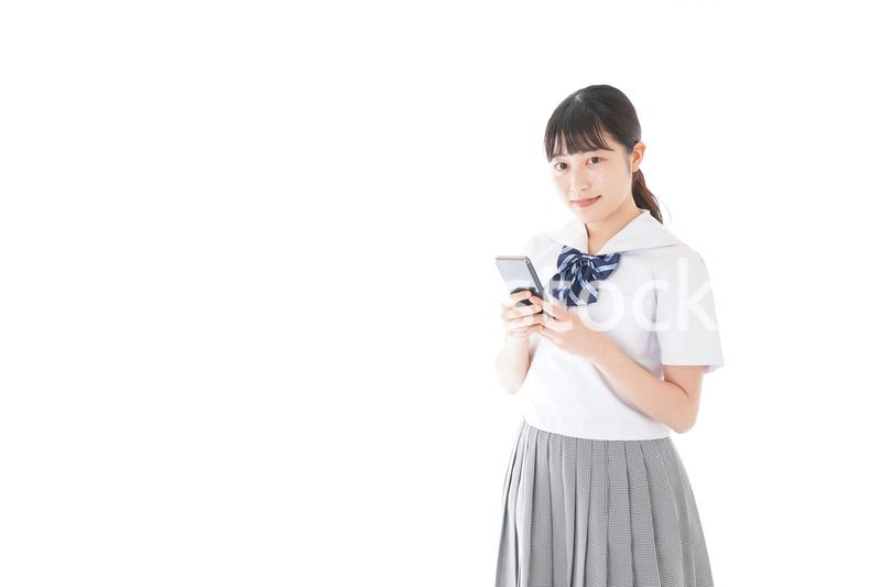 スマホを使う制服姿の女子学生