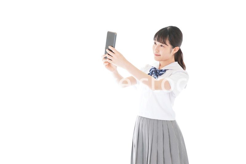 スマホを使う制服姿の女子学生