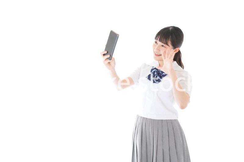 スマホを使う制服姿の女子学生