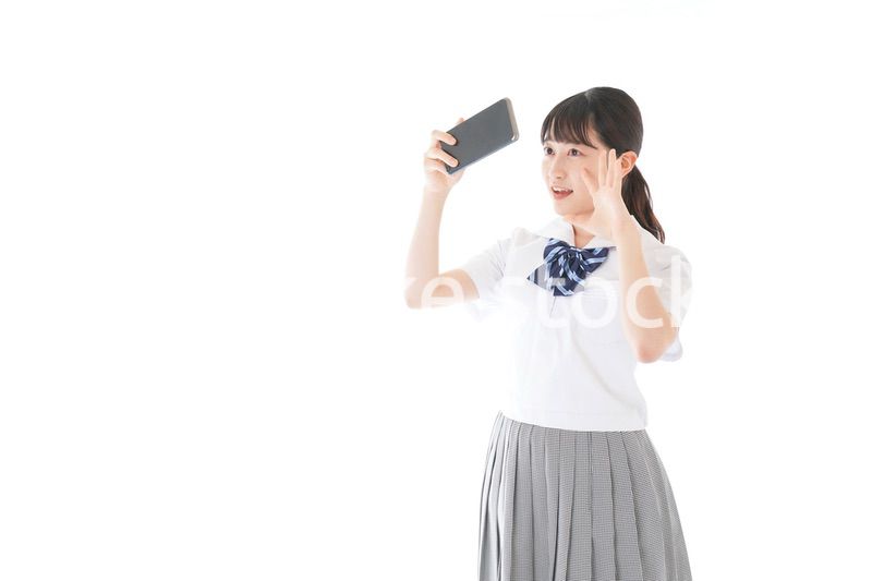 スマホを使う制服姿の女子学生