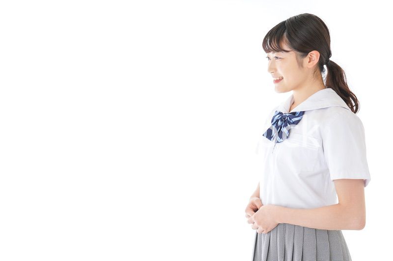 笑顔の若い制服姿の女子学生
