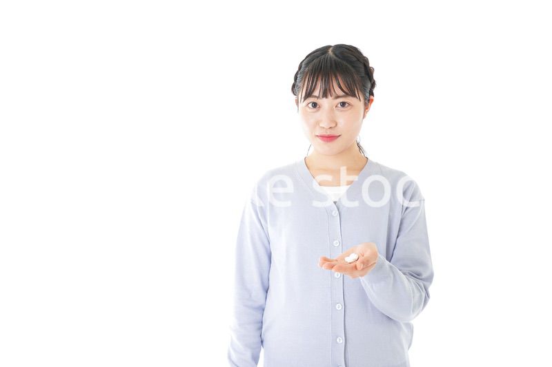薬・サプリメントを服用する若い女性