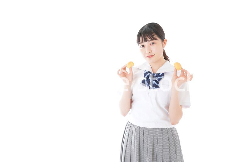 おやつを食べる制服姿の女子学生