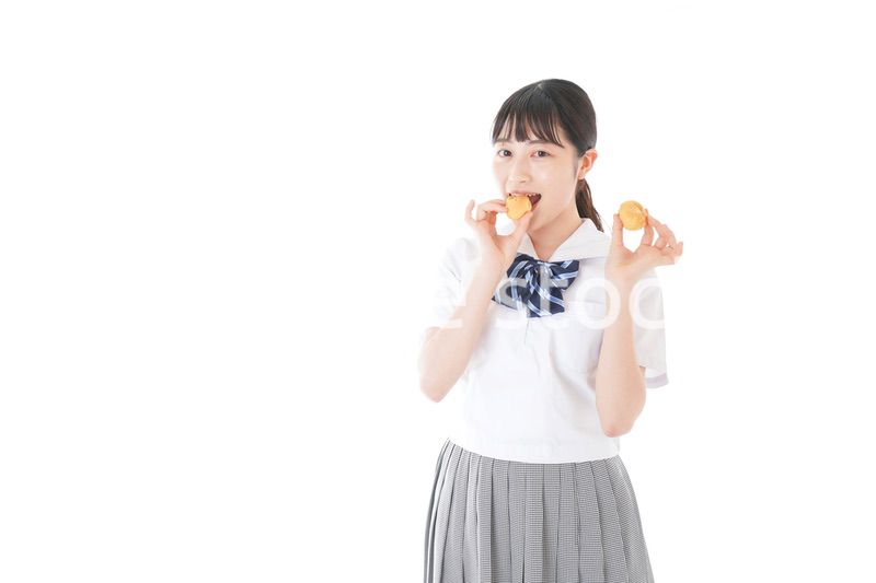 おやつを食べる制服姿の女子学生