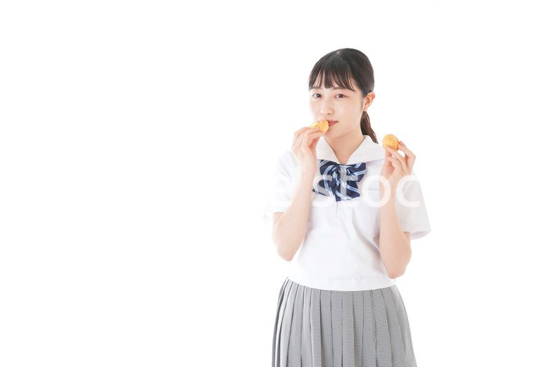 おやつを食べる制服姿の女子学生