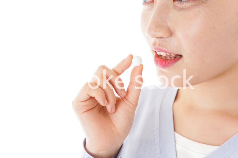 薬・サプリメントを服用する若い女性