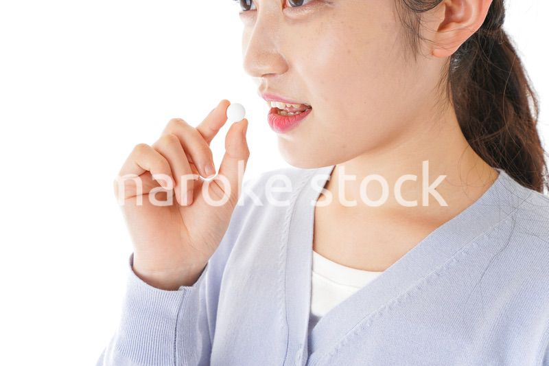 薬・サプリメントを服用する若い女性