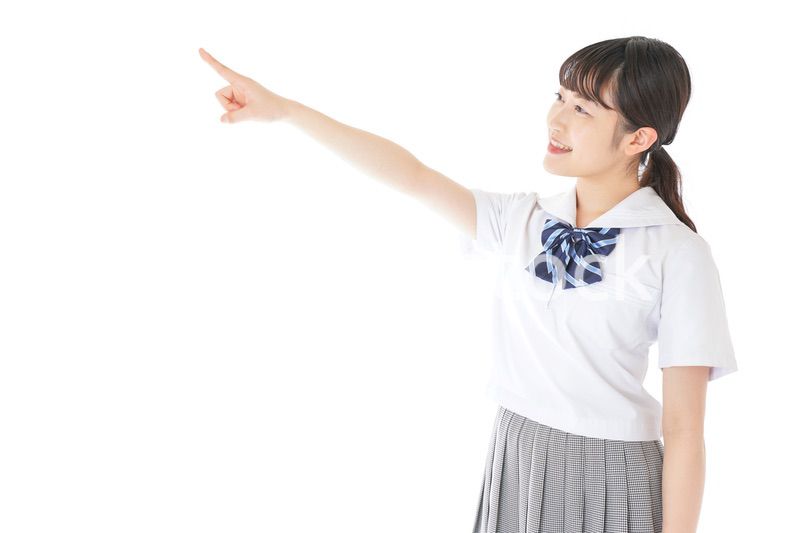 上を指差す制服を着た女子学生