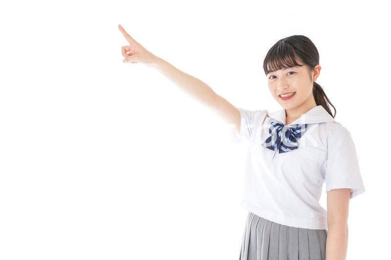 上を指差す制服を着た女子学生