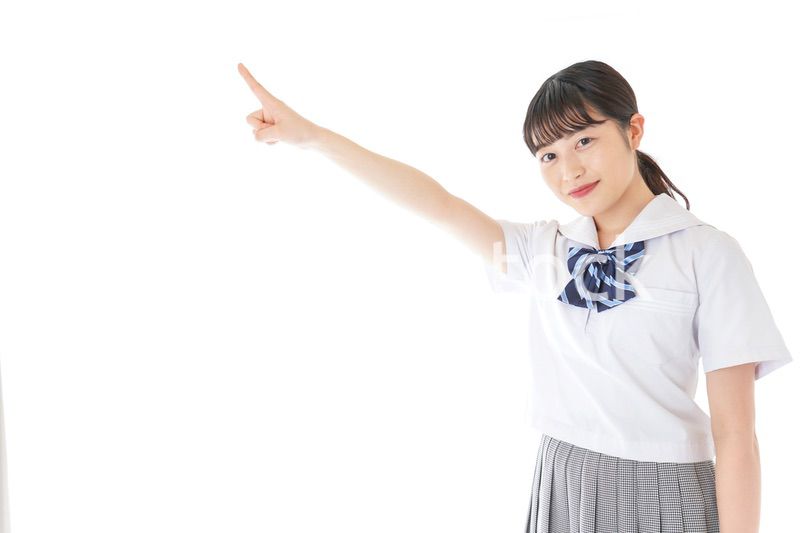 上を指差す制服を着た女子学生