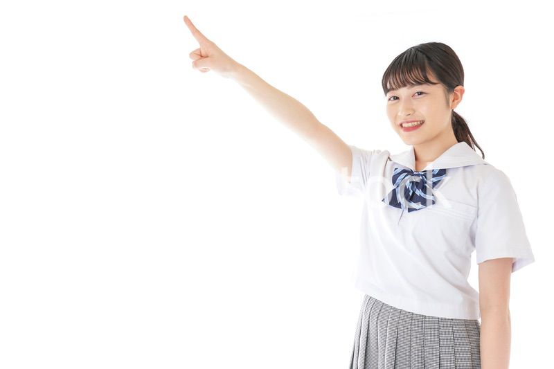 上を指差す制服を着た女子学生