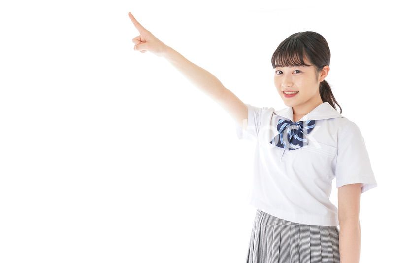 上を指差す制服を着た女子学生
