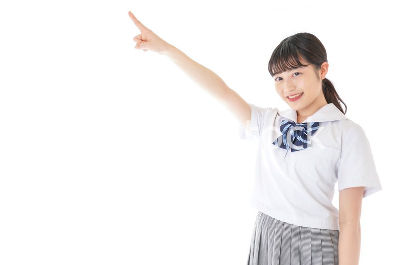 上を指差す制服を着た女子学生