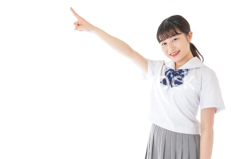 上を指差す制服を着た女子学生