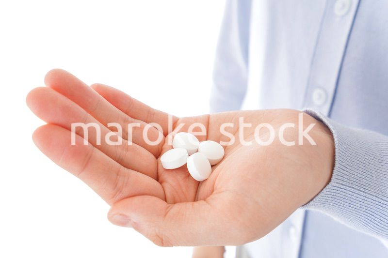 薬・サプリメントを服用する若い女性