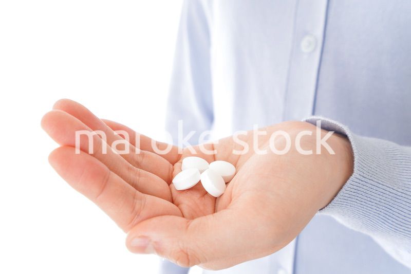 薬・サプリメントを服用する若い女性