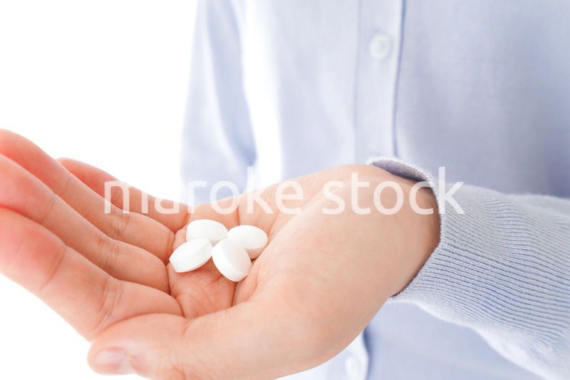 薬・サプリメントを服用する若い女性