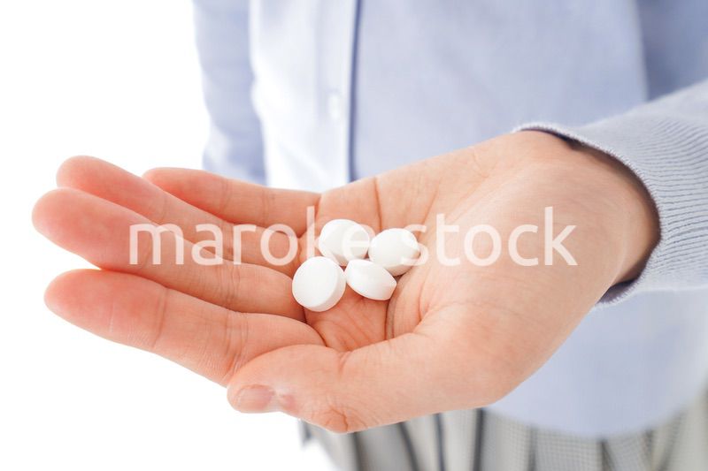 薬・サプリメントを服用する若い女性