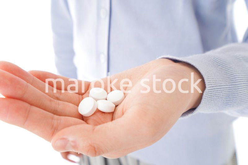 薬・サプリメントを服用する若い女性