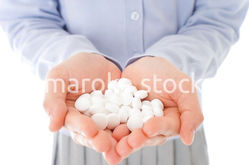 大量の薬物を飲む若い女性