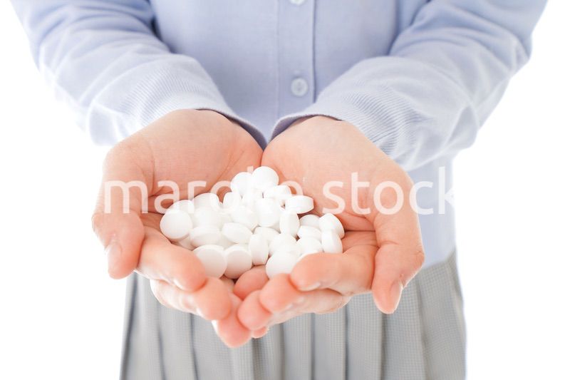 大量の薬物を飲む若い女性