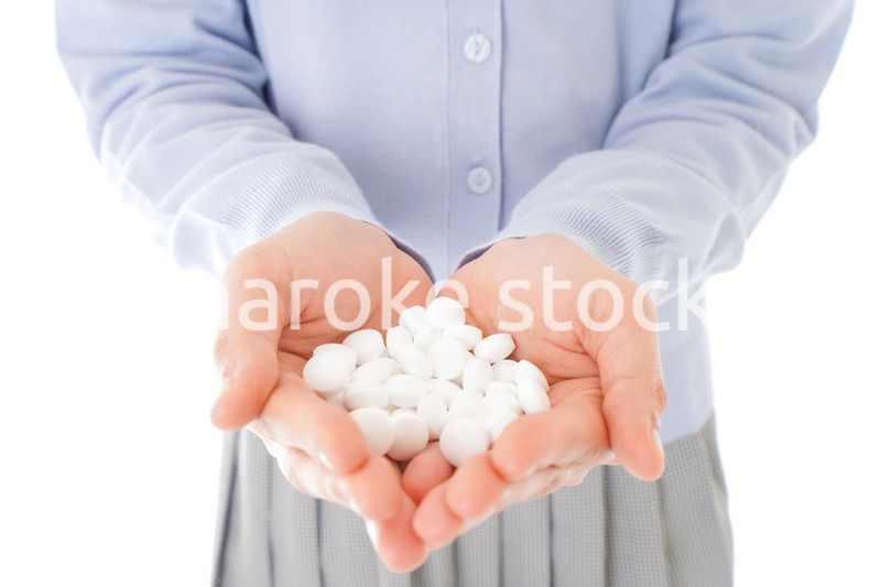 大量の薬物を飲む若い女性