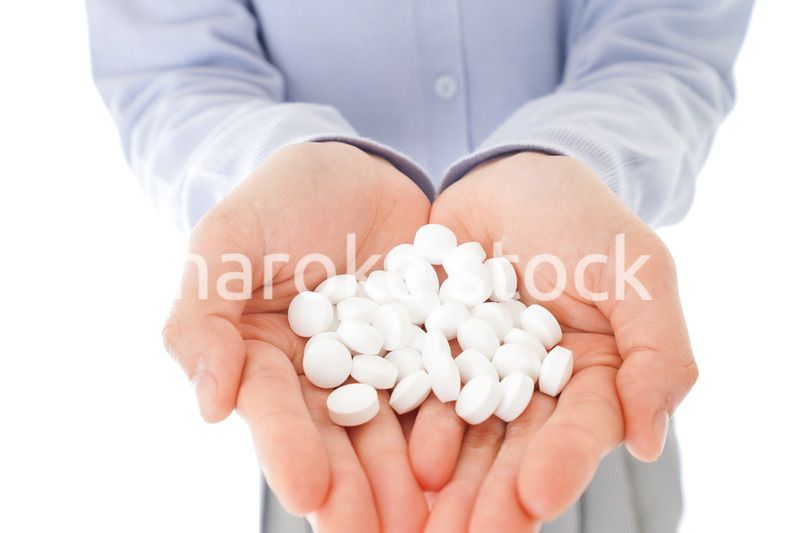 大量の薬物を飲む若い女性