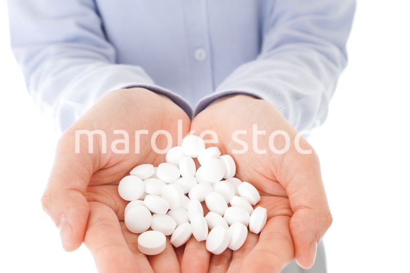 大量の薬物を飲む若い女性