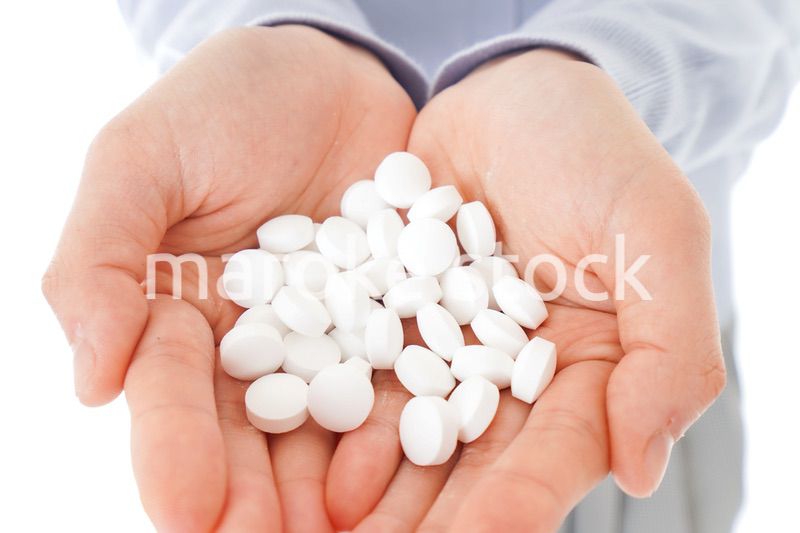 大量の薬物を飲む若い女性