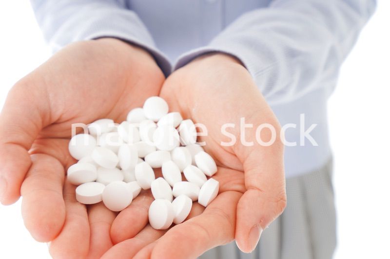 大量の薬物を飲む若い女性