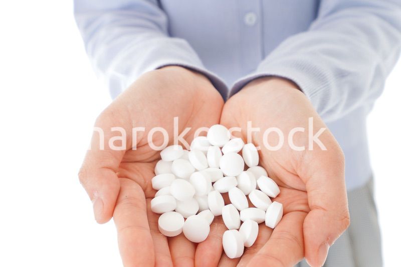 大量の薬物を飲む若い女性