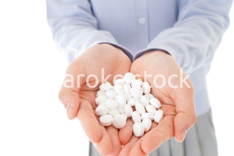 大量の薬物を飲む若い女性