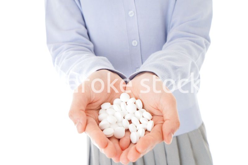 大量の薬物を飲む若い女性