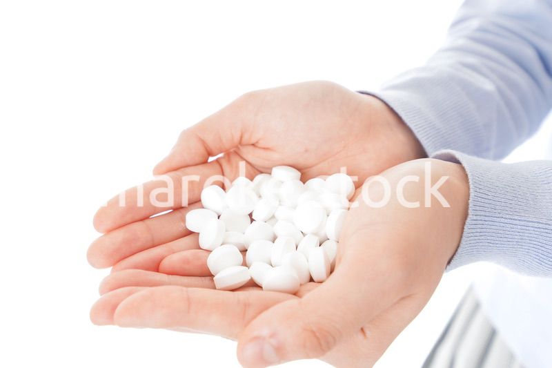 大量の薬物を飲む若い女性