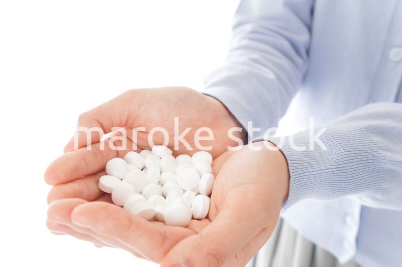 大量の薬物を飲む若い女性