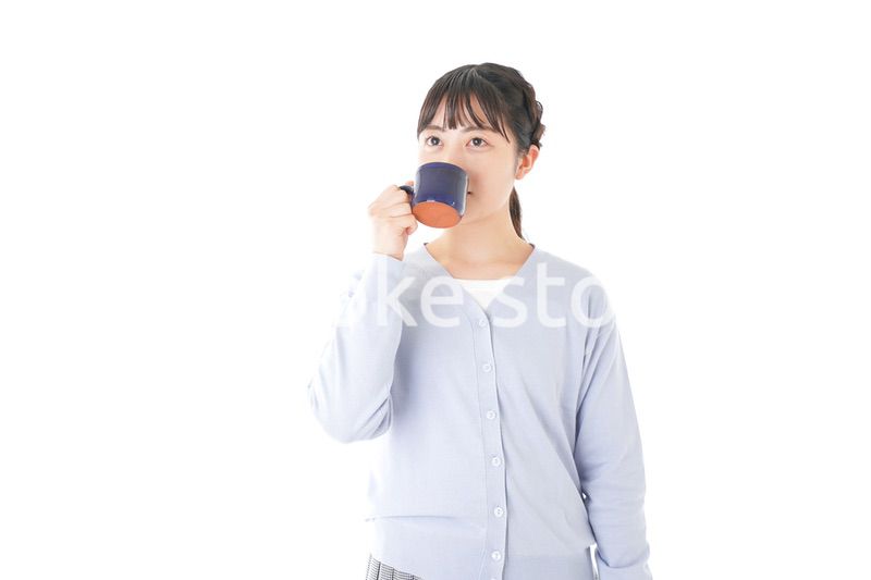 マグカップでコーヒーを飲む若い女性