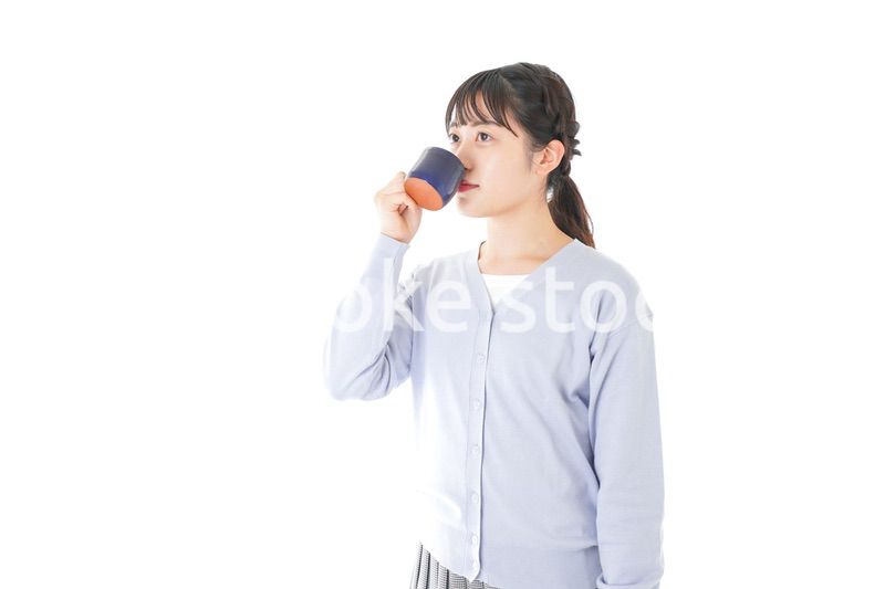 マグカップでコーヒーを飲む若い女性