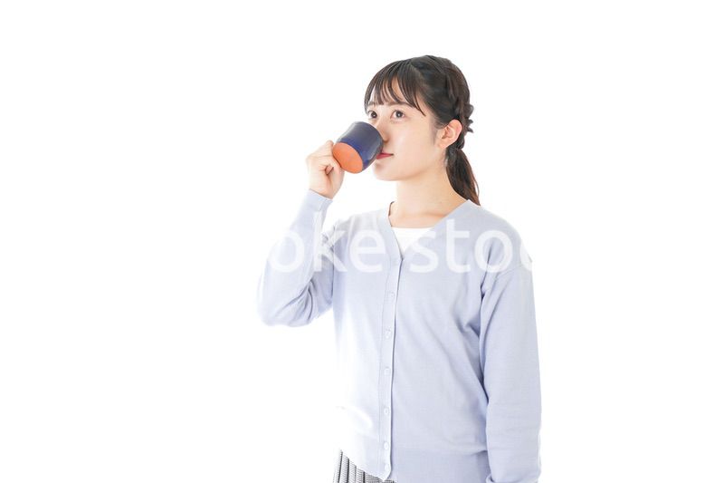 マグカップでコーヒーを飲む若い女性