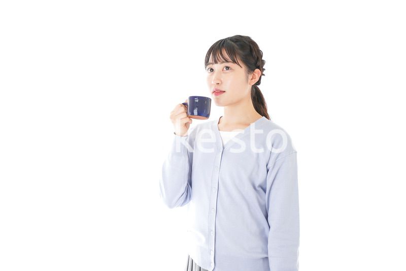 マグカップでコーヒーを飲む若い女性