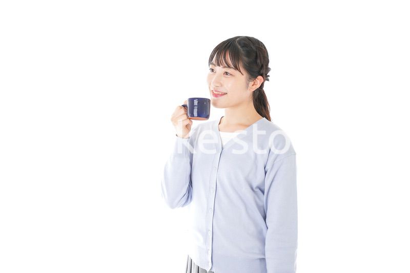 マグカップでコーヒーを飲む若い女性