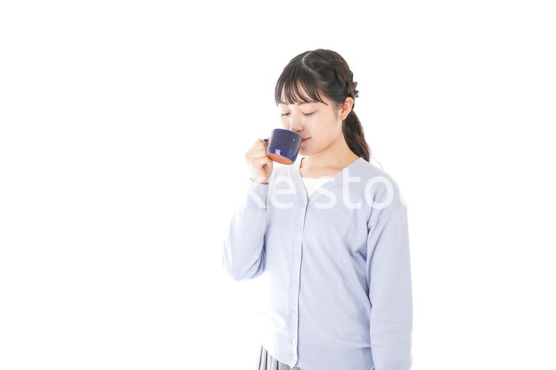 マグカップでコーヒーを飲む若い女性