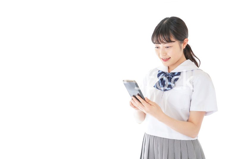 スマートフォンを使う若い女子学生