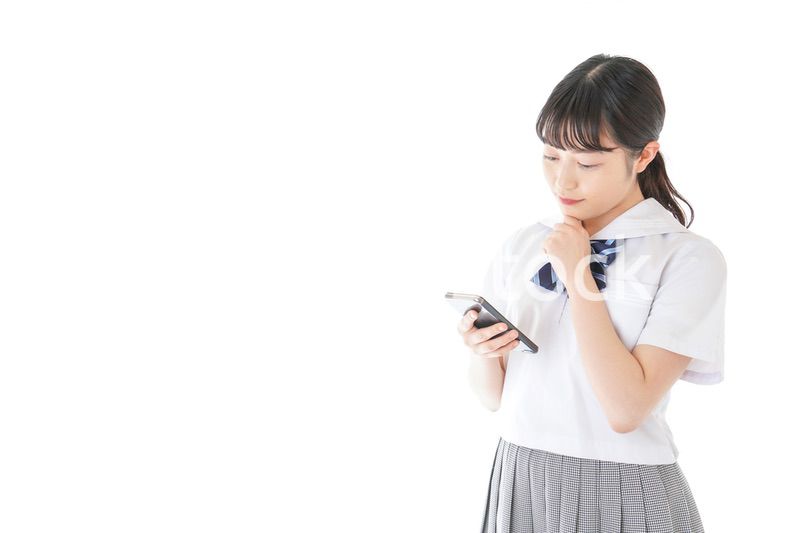 スマートフォンを使う若い女子学生