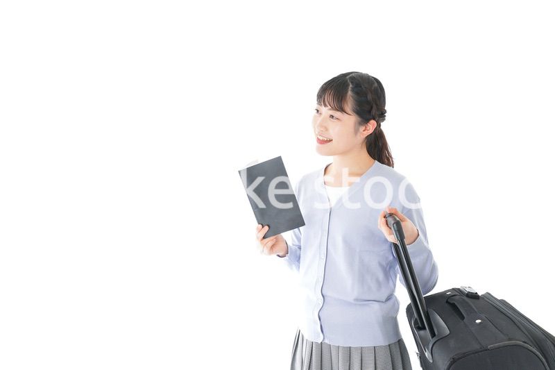 ガイドブックを持ち一人旅をする若い女性