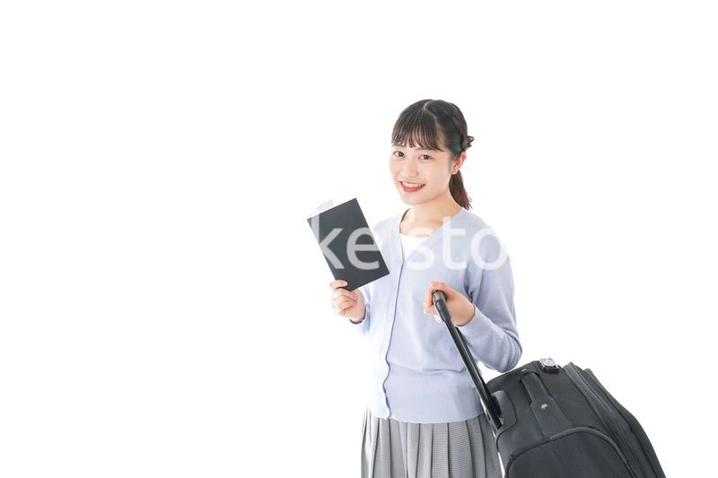 ガイドブックを持ち一人旅をする若い女性