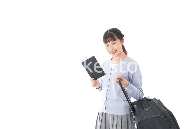 ガイドブックを持ち一人旅をする若い女性