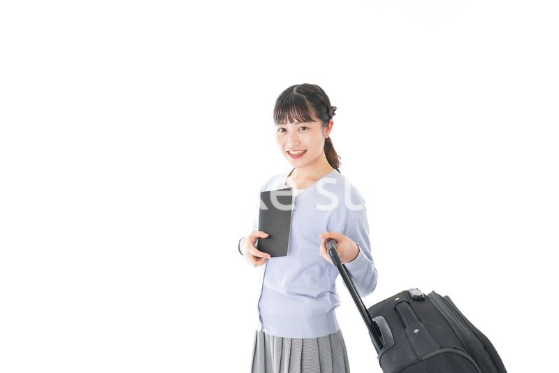 ガイドブックを持ち一人旅をする若い女性