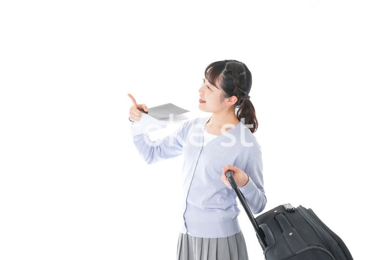 ガイドブックを持ち一人旅をする若い女性