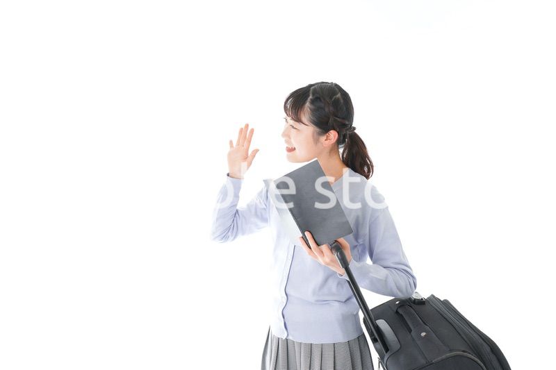 ガイドブックを持ち一人旅をする若い女性